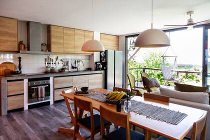 Las puertas ventana integran el afuera con el adentro. En la cocina: camino, frutera, vajilla, todo de Gloria Atelier (@gloriaatelierdeco); aromatizador y velas de AA Elements (@aaelements)