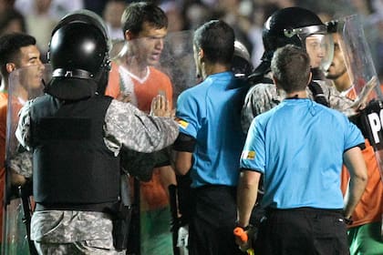 Civelli encabeza las quejas de los jugadores de Banfield con el árbitro Ricci, tras el partido; la policía intervino y golpearon a algunos futbolistas