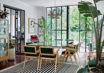 Las sillas al estilo Jeanneret se tapizaron con terciopelo verde esmeralda. Lámpara años 70 original, un clásico del diseñador italiano Gaetano Sciolari.