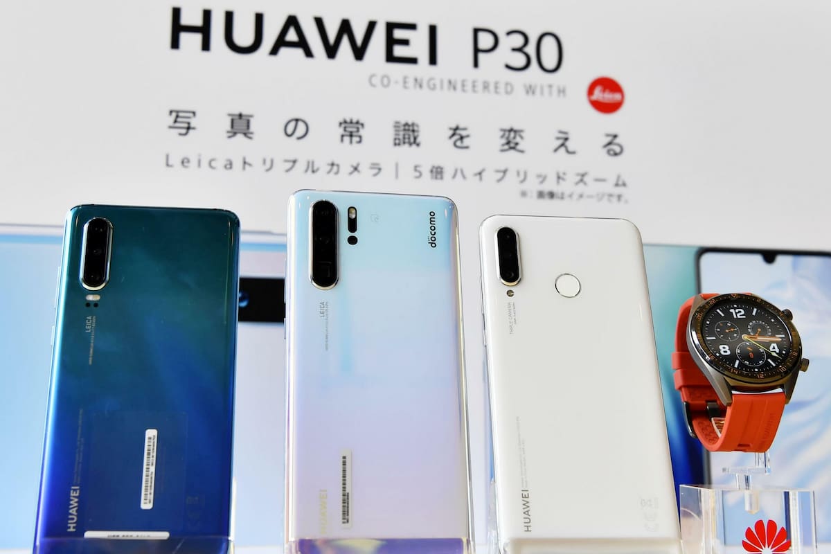 Las tres versiones del teléfono P30 de Huawei junto a un reloj inteligente Huawei Watch