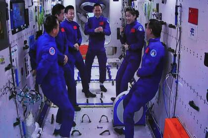 Las tripulaciones de las misiones chinas Shenzhou-15 y Shenzhou-14 tras un histórico encuentro en el espacio, el 30 de noviembre de 2022. Foto difundida por la agencia de noticias Xinhua, tomada de una pantalla del Centro de Lanzamiento Jiuquan en el noroeste de China. (Guo Zhongzheng/Xinhua via AP)