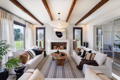 Las vigas en madera de castaño (Familia Echaide) no son meramente decorativas, tienen una función real. Aberturas de PVC símil madera color 'Toffee' (Muchtek). Sillones, alomohadones, alfombra y mesa de centro (Sol Palou Deco).