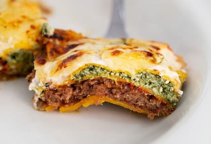 Lasagna de osobuco desmechado, espinaca, ricota y nueces pecan, gratinada con salsa bechamel y queso