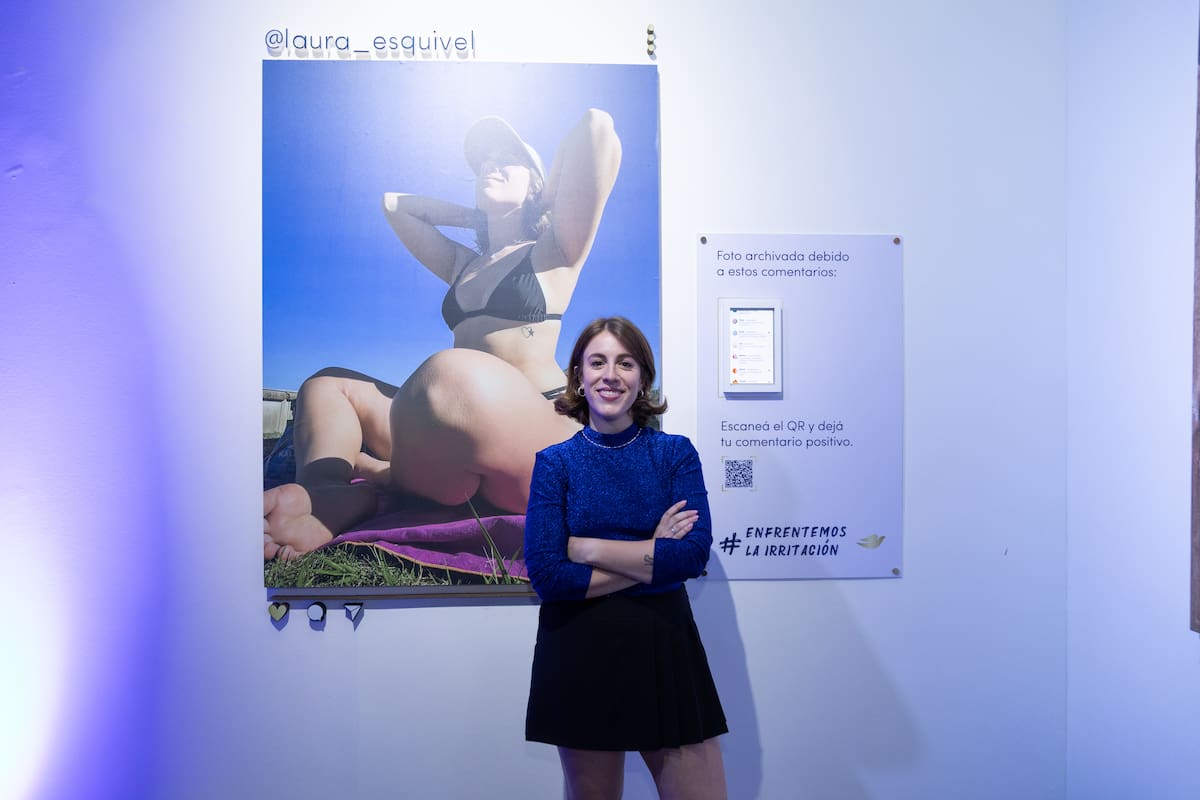 Laura Esquivel, junto a su foto en la muestra, demuestra cuál es la respuesta más poderosa ante el hate: una actitud segura y una sonrisa.