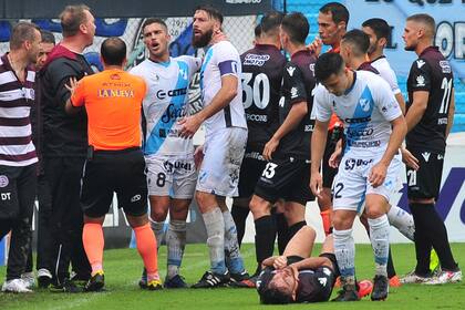Lautaro Acosta, en el suelo tras una falta. Los jugadores de Temperley protestan.
