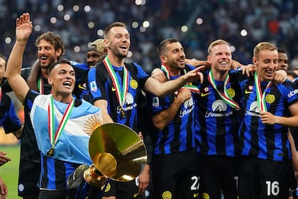 Lautaro, con la bandera argentina colgada de los hombros y el trofeo de campeón de la Serie A
