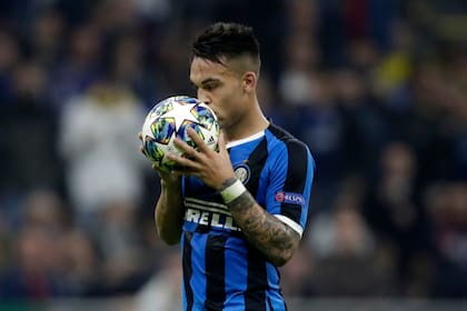 Lautaro Martínez besa la pelota antes de ejecutar el penal que le atajó el arquero de Borussia Dortmund. Antes había anotado un gol.