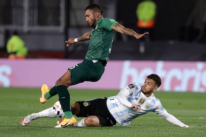 Leandro Paredes va al piso para intentar recuperar ante Adrian Jusino, en el partido que la selección goleó a Bolivia 3-0