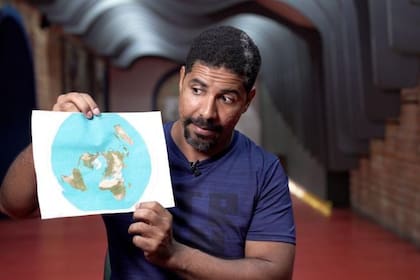 Leandro sostiene un mapa de la tierra plana: hoy reconoce que la imagen no tiene sentido.