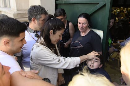 Leda Bergonzi (44), la mujer a la que se le atribuyen dotes sanadores, hace imposición de manos sobre un niño