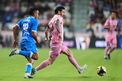 Leo Messi con la pelota, ante la marca de Carlos Rodríguez