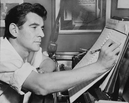 Leonard Bernstein haciendo anotaciones musicales sentado al piano de su casa de Nueva York, en 1955 (PHOTOQUEST)