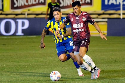 Leonardo Sequeira, que hizo el primer gol para Central Córdoba, se lleva la pelota ante la marca de Gastón Avila, zaguero de Rosario Central; fue 2-2 en el Gigante de Arroyito