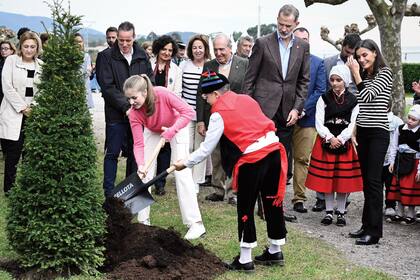 Leonor planta un tejo ante la atenta mirada de sus padres, los Reyes de España.