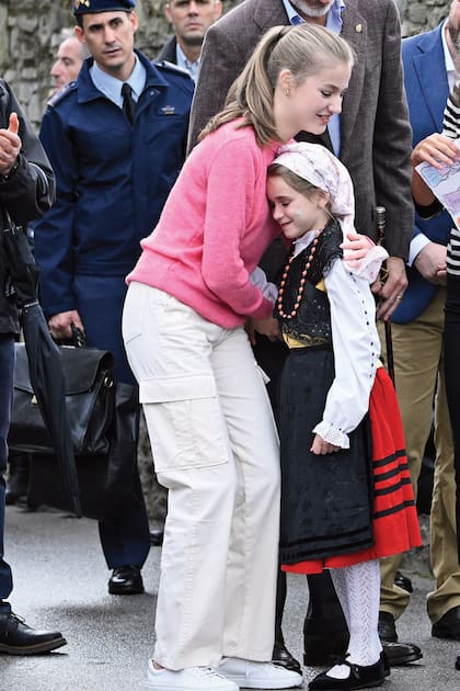 Leonor recibe el cariño de una niña vestida con traje típico en Cadavedo.