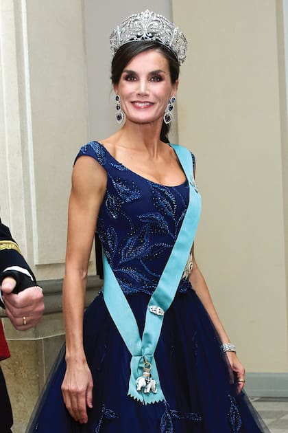 Letizia impactó con una de las piezas más importantes de las joyas de la familia real española: la Tiara de Lis, creada en 1906 por la firma Ansorena en platino y brillantes que representan la flor de lis heráldica de los Borbones. Un look que completó con unos espectaculares pendientes largos de zafiros.