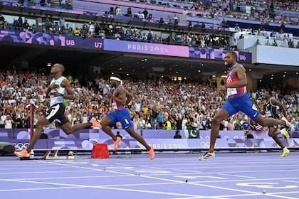 Letsile Tebogo curza la meta primero, delante de Kenneth Bednarek y Noah Lyles en la final de los 200 metros masculinos de París 2024, en el Stade de France de Saint Denis.