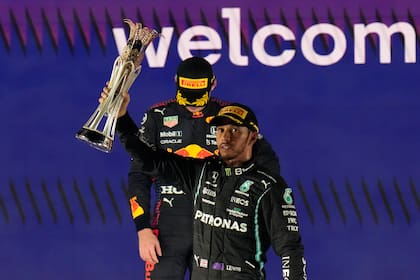Lewis Hamilton celebra la victoria en el Gran Premio de Arabia Saudita; detrás, Max Verstappen evita mantener contacto visual con el vencedor y contra quien definirá el título del Mundial de Pilotos el domingo en Abu Dhabi
