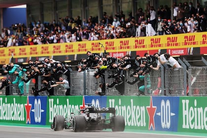 Lewis Hamilton cruza la meta y el equipo Mercedes celebra el histórico triunfo; el piloto británico reescribe la Fórmula 1