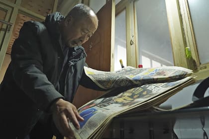 Li Eryou con un diario con noticias del MH370