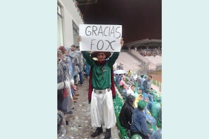 Una postal moderna de la Libertadores: un hincha levanta un cartel para salir en TV.
