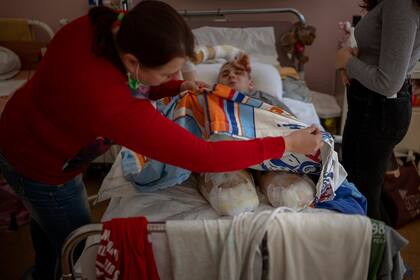 Lidiya Gladun revisa los vendajes de su hijo Anton en un hospital de Cherkasy (Ucrania) el 6 de mayo del 2022. Anton perdió partes de ambas piernas y del brazo izquierdo en la guerra con Rusia. (AP Photo/Emilio Morenatti)