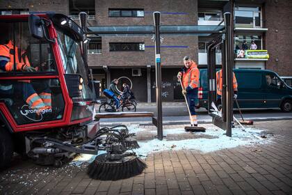 Limpieza en las calles tras una noche de protestas contra las restricciones y las medidas por la vacunación contra el coronavirus en Groningen. Photo: Corné Sparidaens/ANP/dpa
