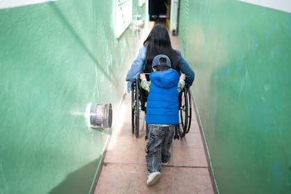 Lionel ayuda a su mamá con su silla de ruedas; para él es un juego más