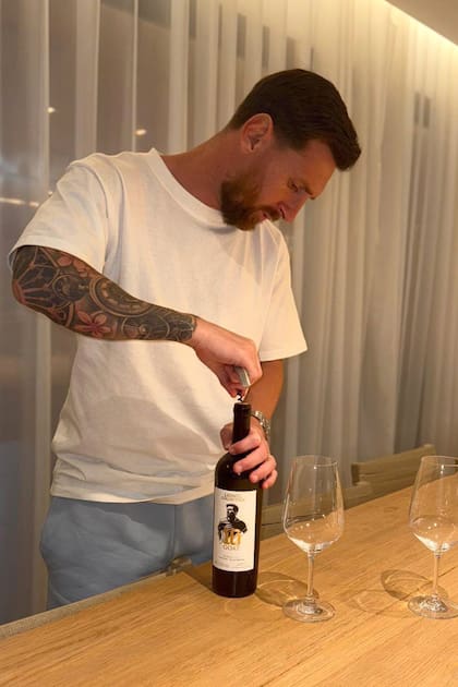 Lionel Messi abre uno de sus vinos, elaborado en Italia