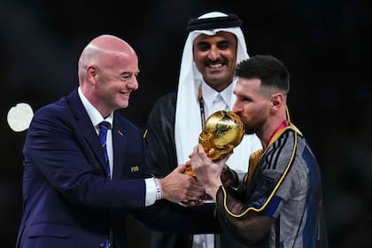 Lionel Messi besa el trofeo de la Copa Mundial entregado por el presidente de la FIFA Gianni Infantino. El mandamás confía en que el capitán argentino juegue el próximo Mundial, en Estados Unidos