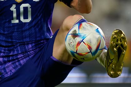 Lionel Messi, con sus botines dorados y la pelota Al Rihla, que se usará en el Mundial de Qatar