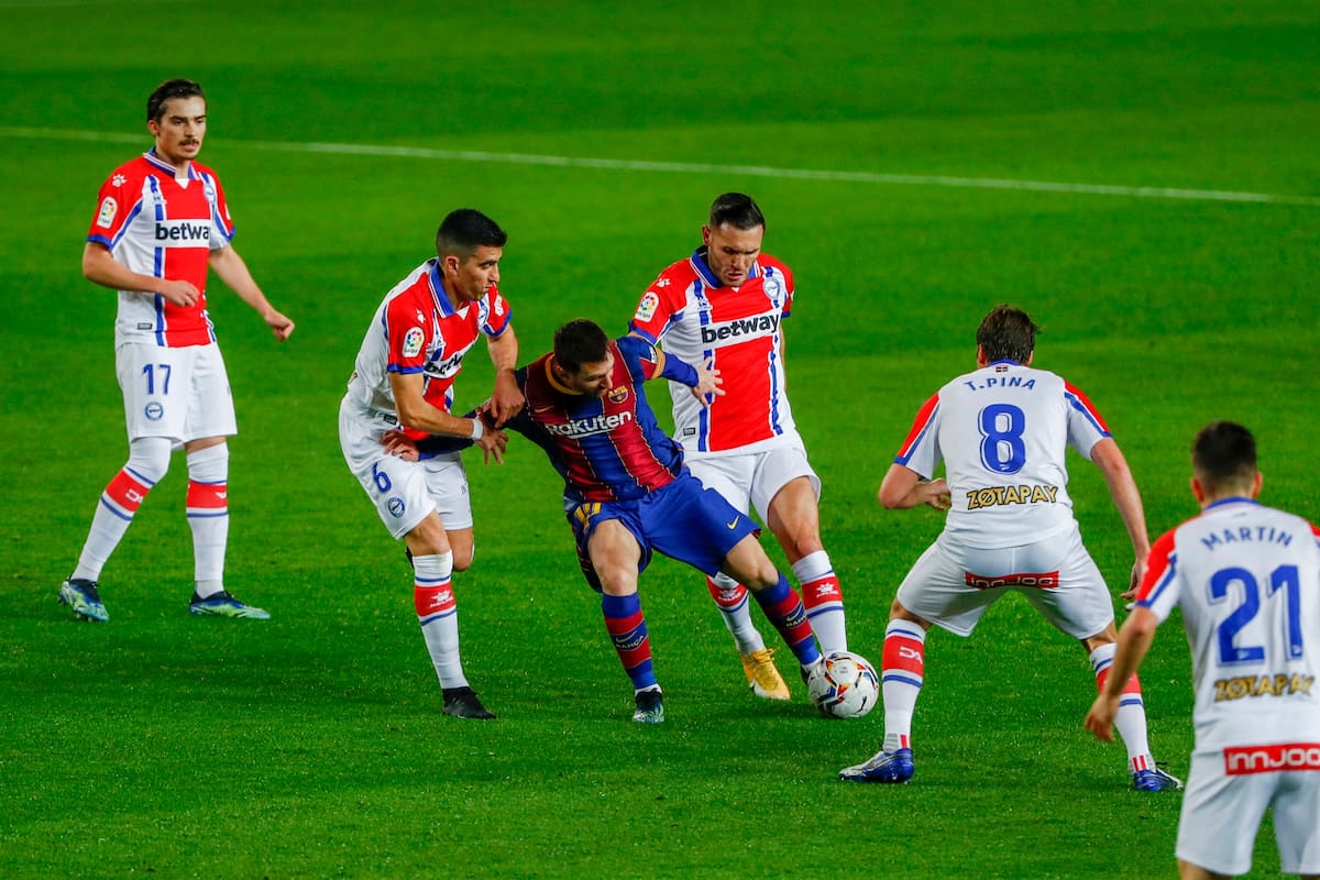 Lionel Messi corre rodeado de jugadores del Alavés durante el partido de fútbol de la Liga española entre FC Barcelona y Alavés en el estadio Camp Nou en Barcelona, España, el sábado 13 de febrero de 2021.