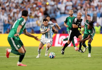 Lionel Messi encara con la pelota ante la marca de los jugadores de Argelia
