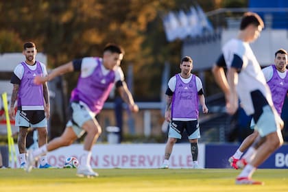 Lionel Messi, junto a Cristian Romero, Thiago Almada, Marcos Acuña y otros jugadores en un ejercicio con la pelota, en el entrenamiento abierto de este miércoles de la selección argentina en Ezeiza.