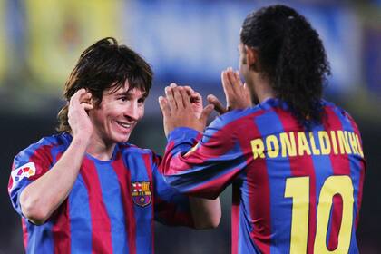Lionel Messi (L) y Ronaldinho compañeros de Barcelona en 2005