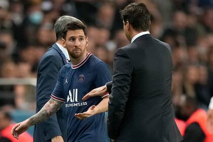 Lionel Messi observa al técnico el PSG Mauricio Pochettino tras ser sustituido en el partido contra Lyon por la liga de Francia, el domingo 19 de septiembre de 2021. (AP Foto/Francois Mori)