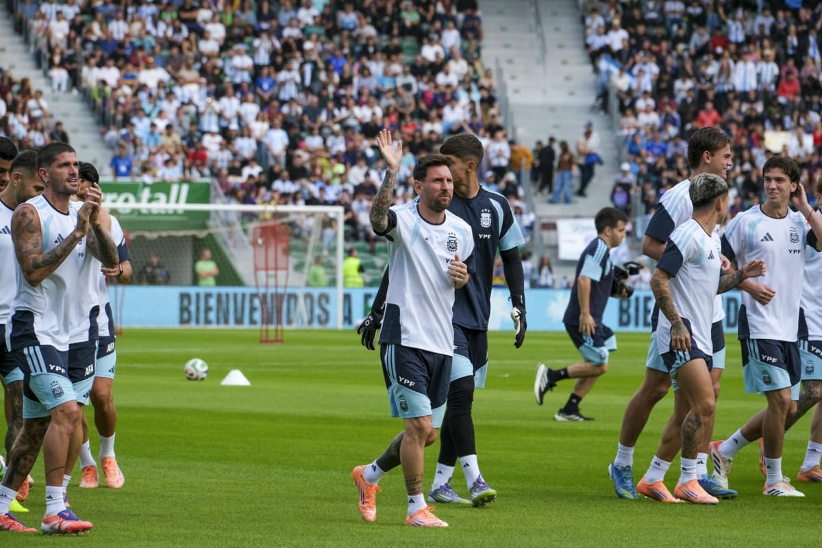 Lionel Messi saluda y Rodrigo De paul aplaude, durante el entrenamiento de la selección argentina en Elche, ante una multitud