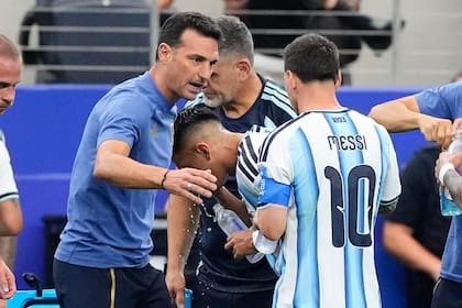 Lionel Scaloni con Messi durante la pausa de hidratación en el partido contra Austria