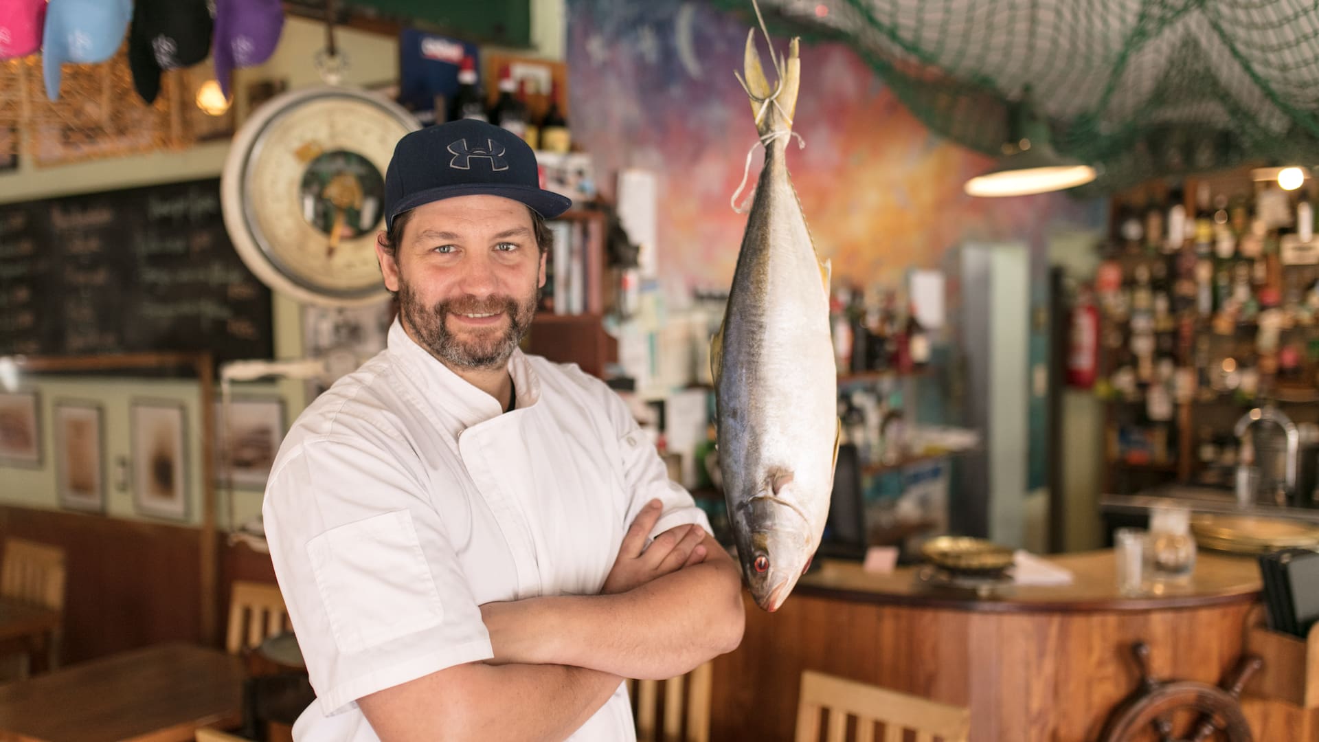 Lisandro Ciarlotti, cocinero y creador de Lo de Tata, sostiene un pez limón de la pesca del día.