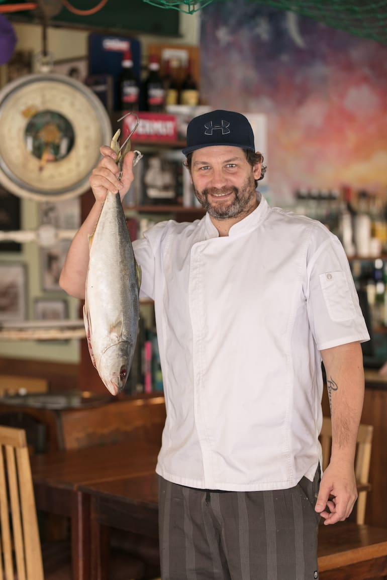 Lisandro Ciarlotti, cocinero y creador de Lo de Tata, sostiene un pez limón de la pesca del día.