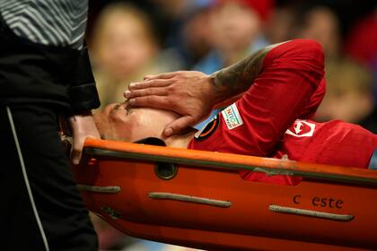 Lisandro Martínez del Manchester United es retirado en camilla tras lesionarse en el partido contra el Sevilla por los cuartos de final de la Liga Europa, el jueves 13 de abril de 2023. (AP Foto/Dave Thompson)