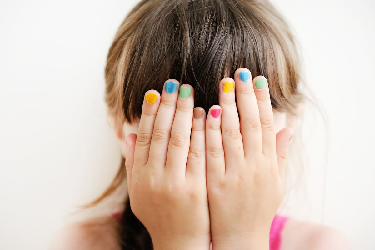 Little girl with her hands covering her eyes, see no evil