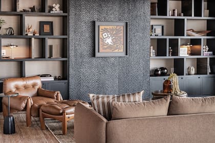 Mueble a medida (Sofía Ruiz Estudio) con puerta corrediza que permite ocultar la TV cuando no está en uso. Obra del pintor uruguayo José Pedro Costigliolo. Butaca 'Mole' (Sergio Rodrigues) y sofá (BoConcept).