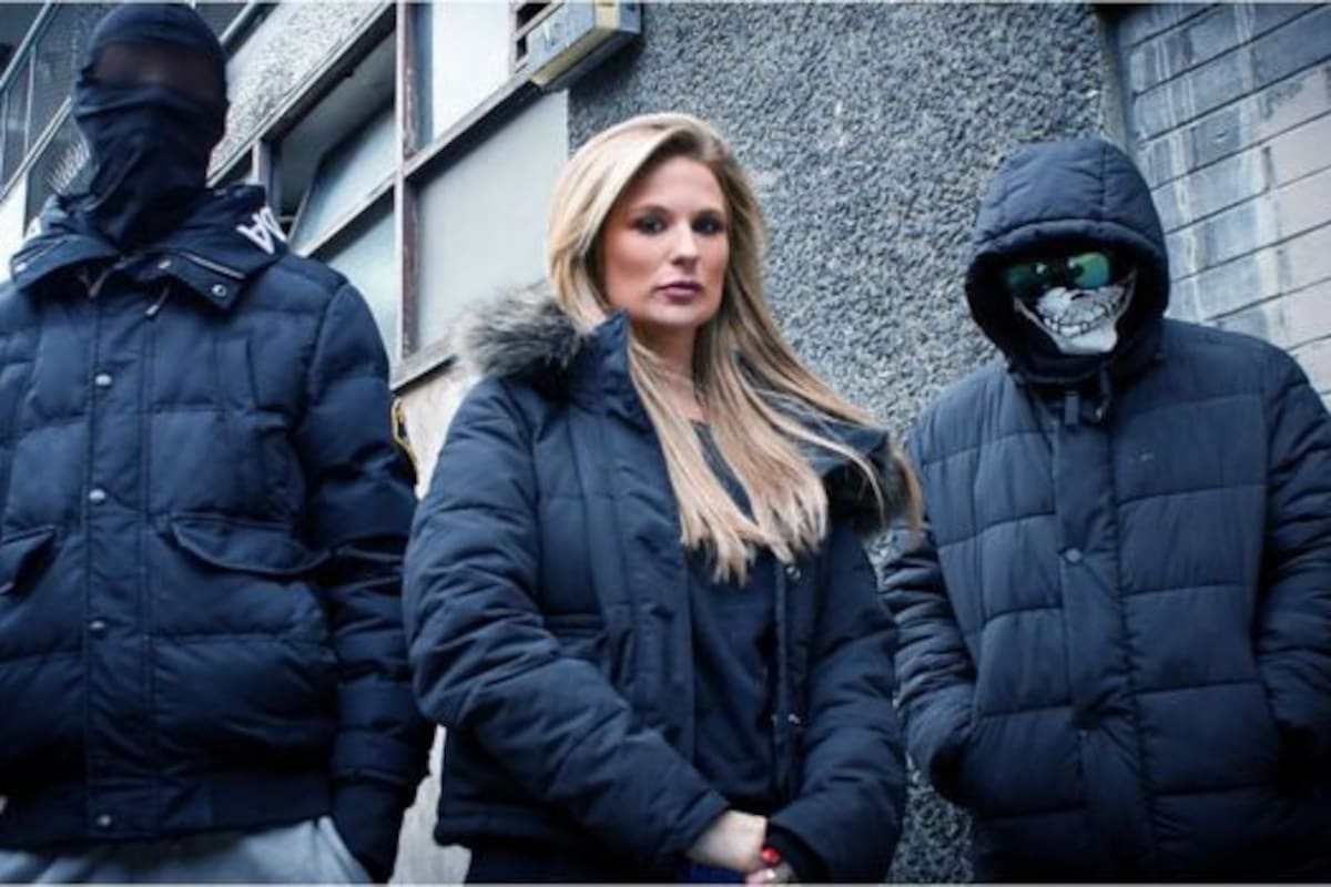 Livvy en medio de dos personas enmascaradas involucradas en bandas de secuestradores