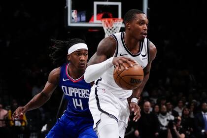 Lonnie Walker IV, de los Nets de Brooklyn, elude a Terance Mann, de los Clippers de Los Ángeles, durante el encuentro del miércoles 8 de noviembre de 2023 (AP Foto/Frank Franklin II)