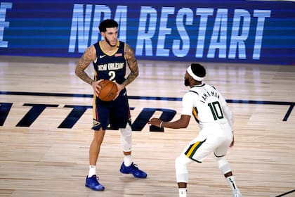 Lonzo Ball es defendido por Mike Conley en el partido que marcó el reinicio de la temporada de la NBA