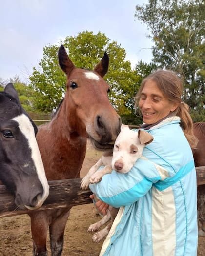 Lorena junto a algunos de sus animales rescatados, en el campo que alquina en Ensenada