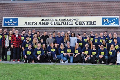 Los actores, músicos y técnicos argentinos del musical posan frente al teatro de Gander. En el centro, Carla Calabrese, y a la izquierda, con campera a cuadros, Enrique Piñeyro, quien aprovechó un vuelo humanitario de la ONG Solidaire que iba a Dallas para levarlos y traerlos.