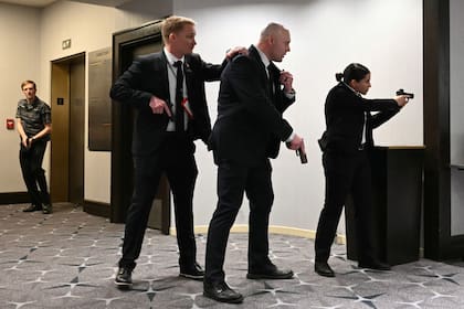 Los agentes desenfundan sus armas tras escucharse fuertes disparos durante la cena de corresponsales de la Casa Blanca en el hotel Washington Hilton de Washington