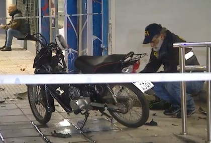 Los agentes verifican la moto que escapó y luego chocó con el patrullero